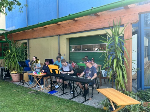 Eine Gruppe von Menschen musiziert mit verschiedenen Instrumenten.