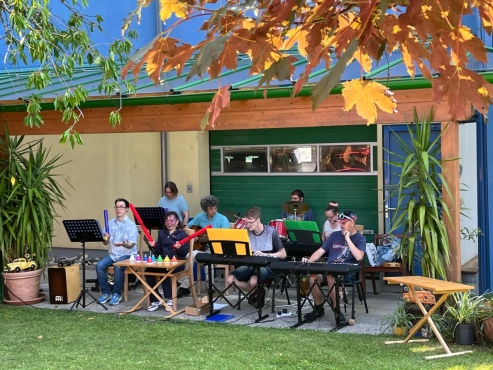Eine Gruppe von Menschen musiziert mit verschiedenen Instrumenten.