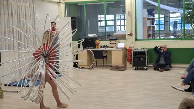 Eine Artistin beim Turnen mit vielen Hula Hoop Reifen.