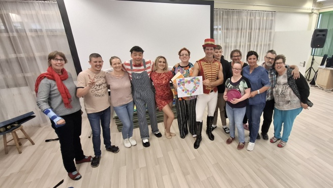 Eine Gruppe von Menschen posiert und lächelt in die Kamera.