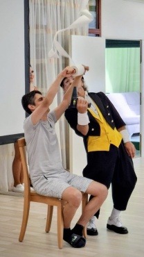 Ein Clown und ein Mann beim Auff&uuml;hren eines Zaubertricks.