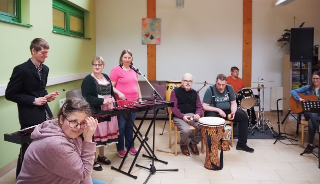 Eine Gruppe von Menschen beim Singen und Musizieren auf verschiedenen Instrumenten.