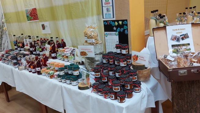 Verkaufsstand mit verschiedenen Marmeladen, Saftflaschen und Lik&ouml;rflaschen.