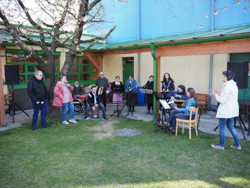 Eine Gruppe von Menschen beim Singen und Musizieren auf verschiedenen Instrumenten.
