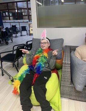 1 verkleidete Person im Sitzen l&auml;chelt in die Kamera.