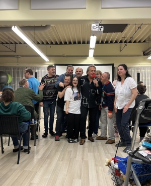 8 Personen l&auml;cheln in die Kamera.