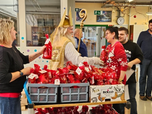 der Nikolaus überreicht ein Geschenk an eine Frau.