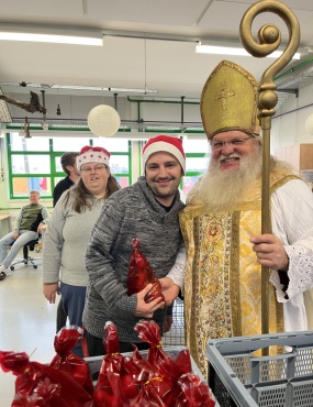 3 Personen l&auml;cheln in die Kamera. Sie halten Nikolosackerl in den H&auml;nden.