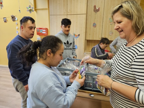 Eine Frau &uuml;berreicht ein Geschenksackerl an eine Frau.