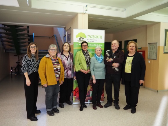 7 Personen l&auml;cheln in die Kamera.